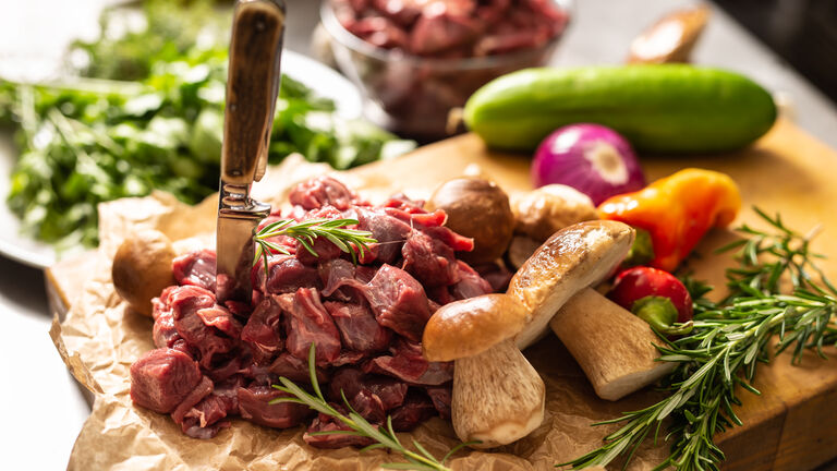 Rohe Hirschfleischstücke mit Gemüse