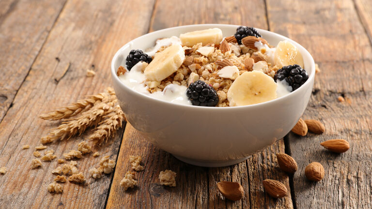 Müslischüssel mit Banane, Joghurt und Brombeeren