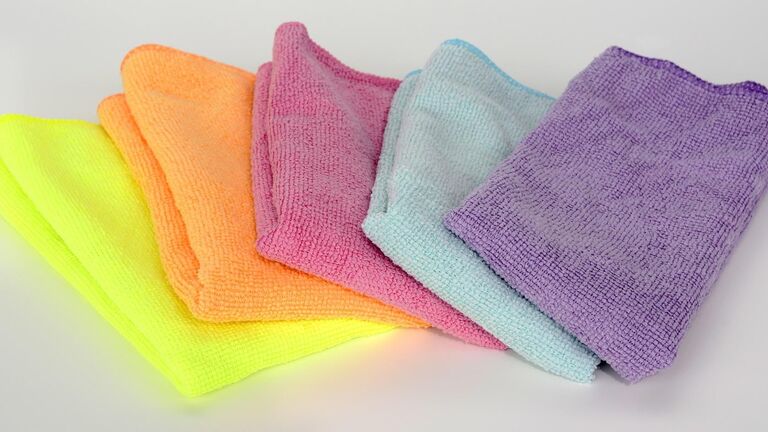 Mehrere Putzlappen in den Farben gelb, orange, rosa, hellblau und lila