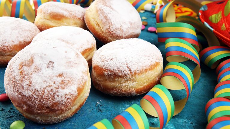 mit Puderzucker bestäubte Kräppel und Luftschlangen