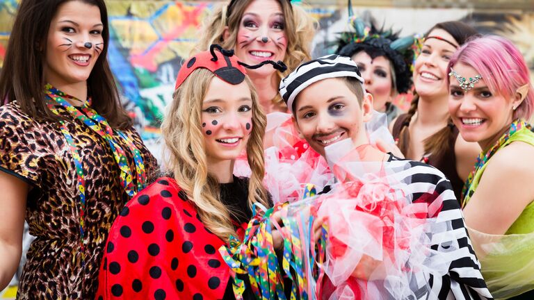 Junge kostümierte Frauen feiern ausgelassen im Freien Fasching
