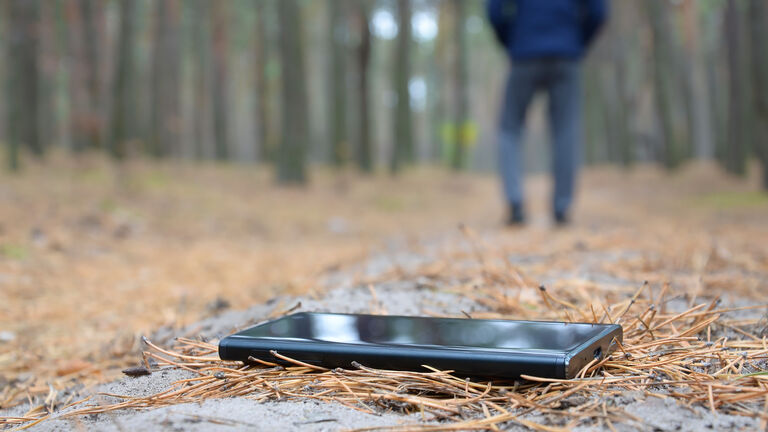 Ein Mann verliert sein Handy auf einem Waldweg