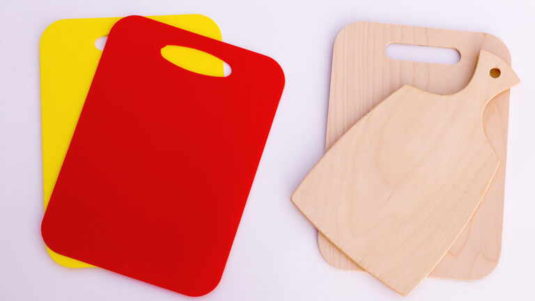 Je zwei Schneidebretter aus Plastik und aus Holz nebeneinander