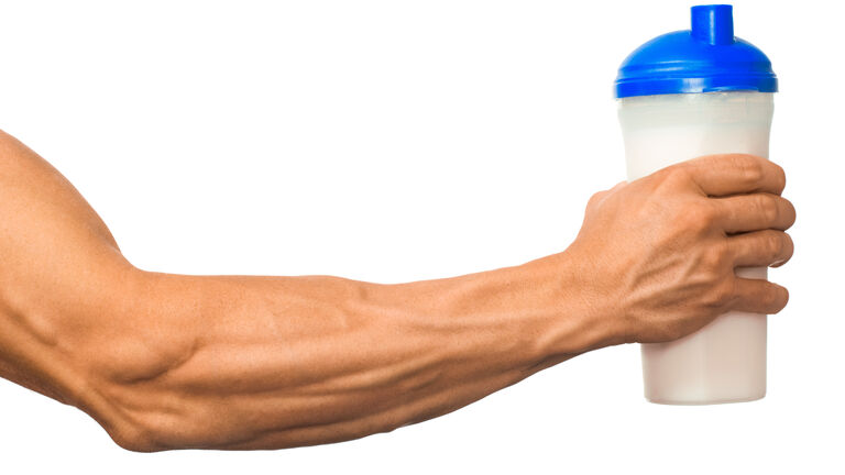 Ein durchtrainierter Oberarm hält eine Shakegefäß in der Hand