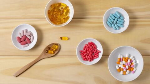 Schälchen mit Tabletten auf einer Holzfläche