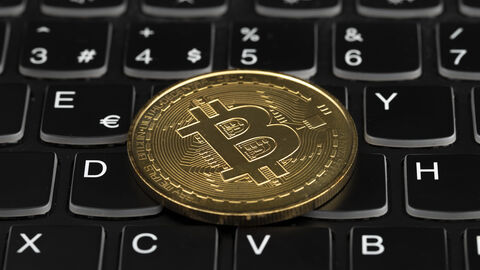 Eine Bitcoinmünze liegt auf einer Computertastatur