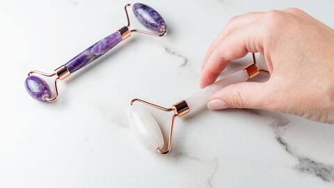 Weibliche Hand greift nach einem Edelsteinroller