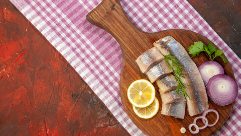 Roher Fisch angerichtet mit Zwiebeln und Zitrone