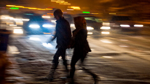 Fußgänger überqueren nachts eine Straße