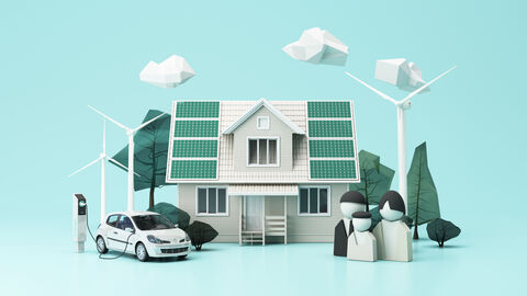 Ein Modellhaus mit Windkraftanlage, Solarenergie und Elektroladestelle für ein Auto