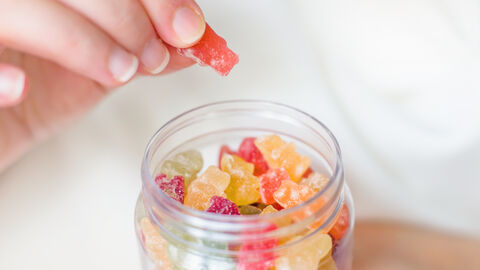 Hand holt Gummibärchen aus einem Glas