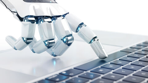 Roboterhand tippt am Laptop