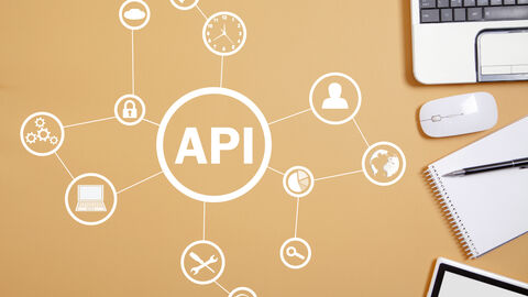 Ein Notebook mit Peripheriegeräten und einem Schreibblock ergänzt um verschiedene Icons aus dem Thema Software