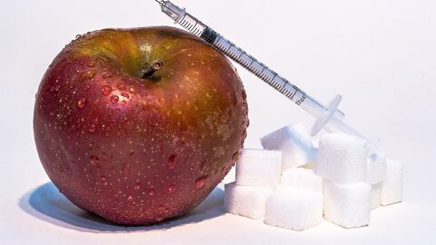 Apfel, Zuckerwürfel und Spritze