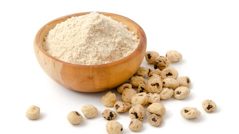 Erdmandelmehl in Holzschale, daneben Erdmandeln