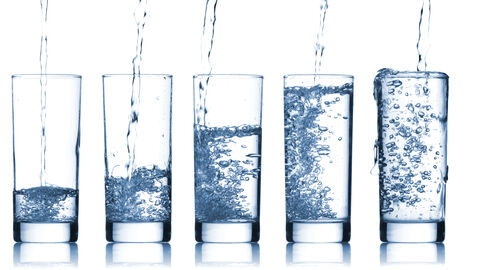 Gläser werden mit Sprudelwasser gefüllt