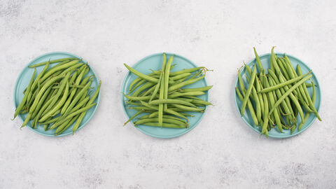 Grüne Bohnen auf drei Tellern von oben