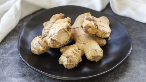 Topinambur Knollen auf einem schwarzen Teller