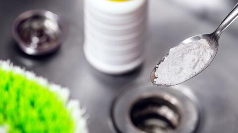 Löffel mit Natron über einer Spüle