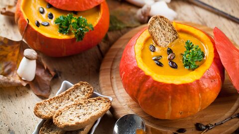 Kürbissuppe in ausgehöhltem Kürbis mit gerösteter Brotscheibe