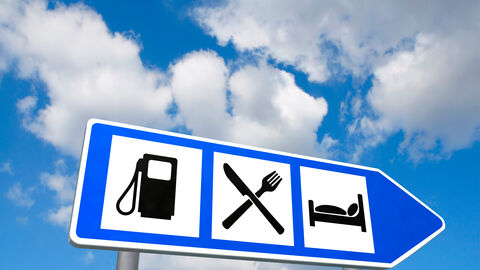 Ausfahrtsschild für Raststätte mit den Symbolen für Tanken, Essen und Übernachten