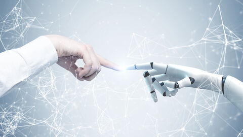 Mensch und KI treffen aufeinander Der Zeigefinger einer menschlichen Hand und der Zeigefinger einer Roboterhand berühren sich