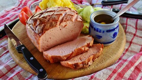 Leberkäse mit Senf und Kartoffelsalat auf Holzbrett