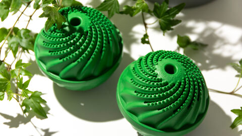 Zwei grüne Waschbälle umringt von einer Efeupflanze