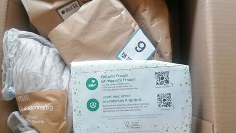 Blick in geöffneten Karton mit mehreren Lebensmitteltüten