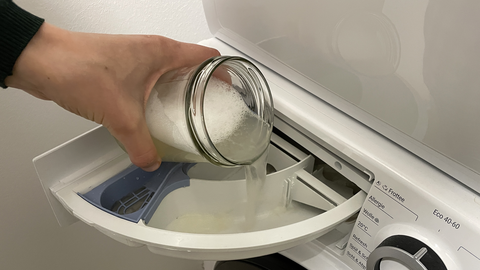 Rosskastaniensud im Schraubglas wird ins Waschmittelfach der Waschmaschine gegeben.