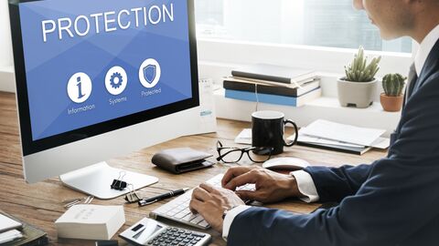 Bildschirm weist mit dem Wort Protection auf den Datenschutz hin Mann sitzt vor dem Bildschirm, auf  dem "Protection" steht