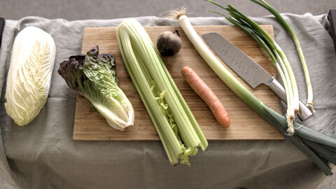 Auf einem Schneidebrett liegt die Gemüseauswahl für den Selbstversuch bereit. Die Auswahl besteht aus Chinakohl, Salat, Sellerie, Karotte, Rote Bete, Lauch und Frühlingszwiebeln.