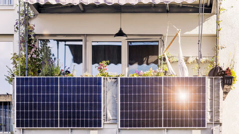 Blick auf ein Balkonkraftwerk, dass an einem Balkongeländer montiert ist.