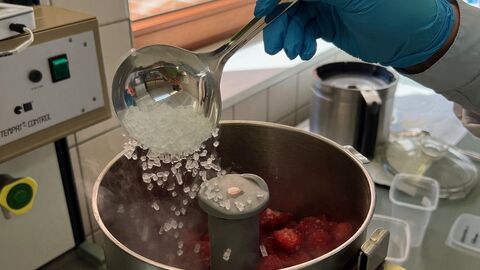 Zu den vorgeschnittenen Erdbeeren wird Trockeneis hinzugefügt Zu den vorgeschnittenen Erdbeeren wird Trockeneis hinzugefügt